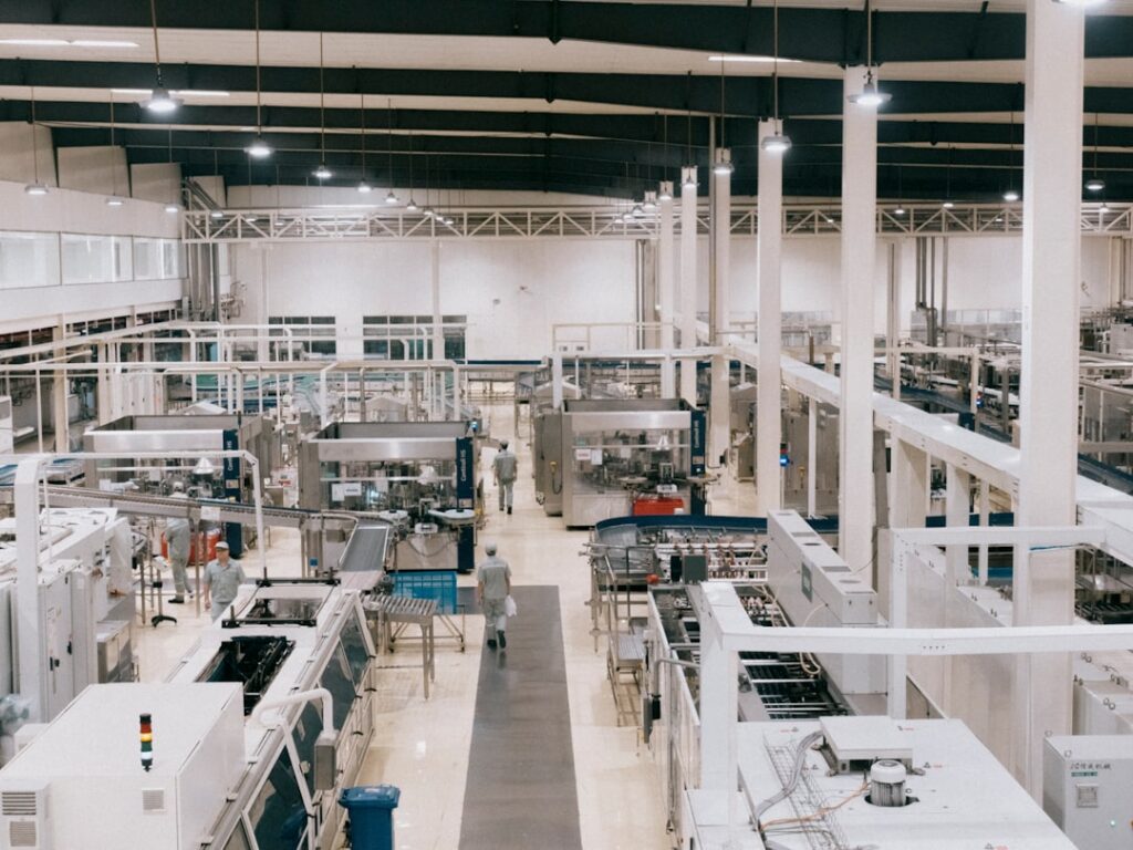 Workers in cleanroom suits inspect semiconductor wafers at a TSMC fabrication plant, highlighting advanced chip assembly technology.