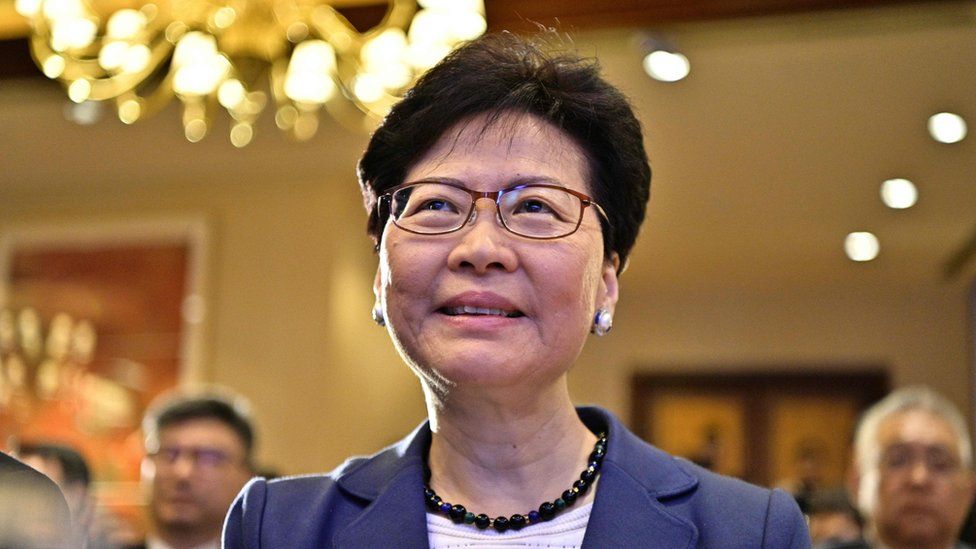 Carrie Lam speaking at an Asian Financial Forum event in Hong Kong, addressing business leaders and investors.